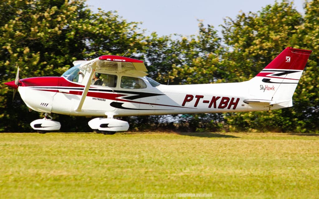 Cessna C172 Skyhawk matrícula PT-KBH decolando na pista de grama